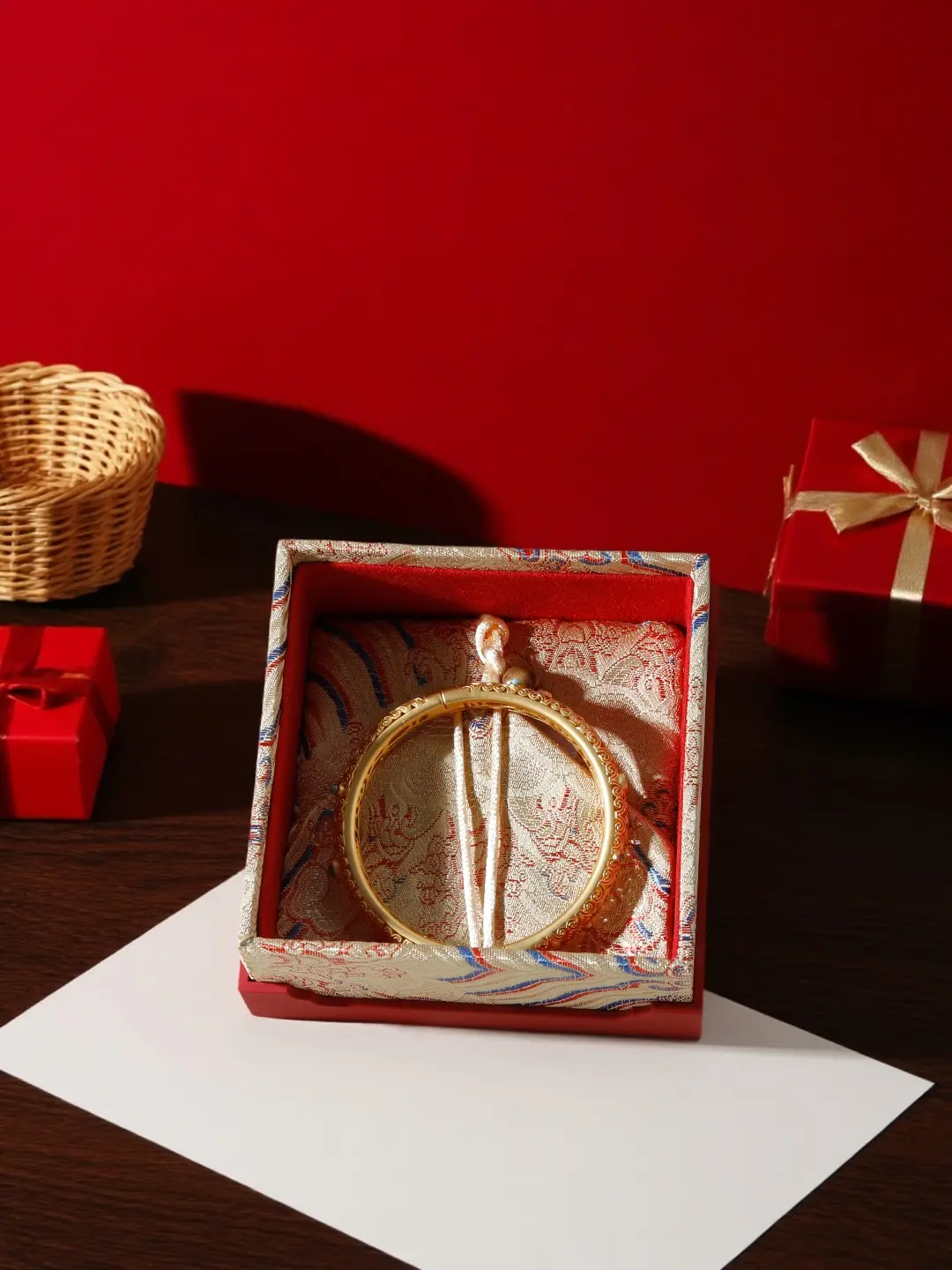 Open Chinese wedding jewelry gift box with gold bangle on brocade lining