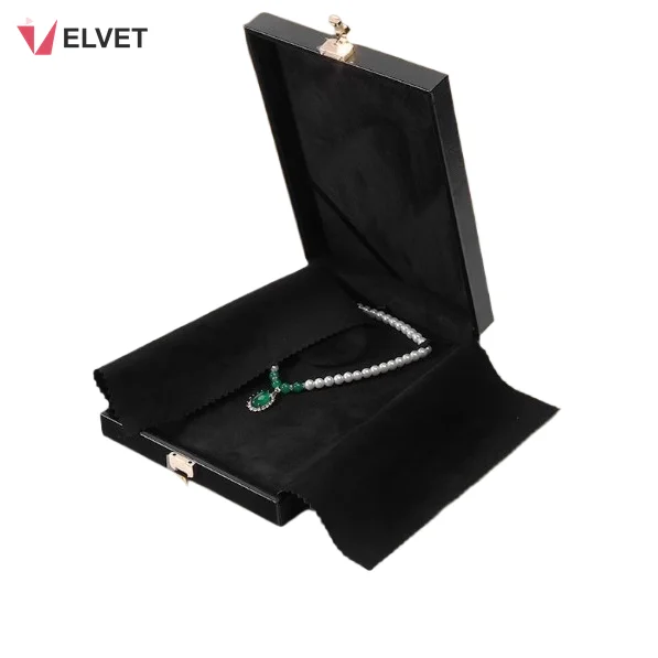 Black suede necklace set presentation box opened flat with fold-out dust cover and a gemstone necklace
