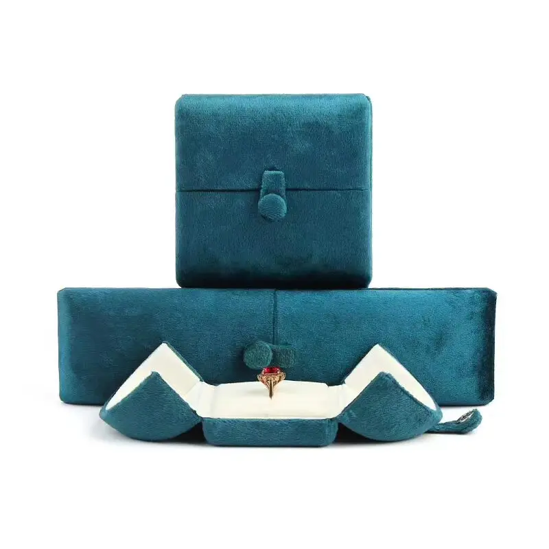 Petal-open velvet jewelry box opened to reveal interior with red gemstone ring