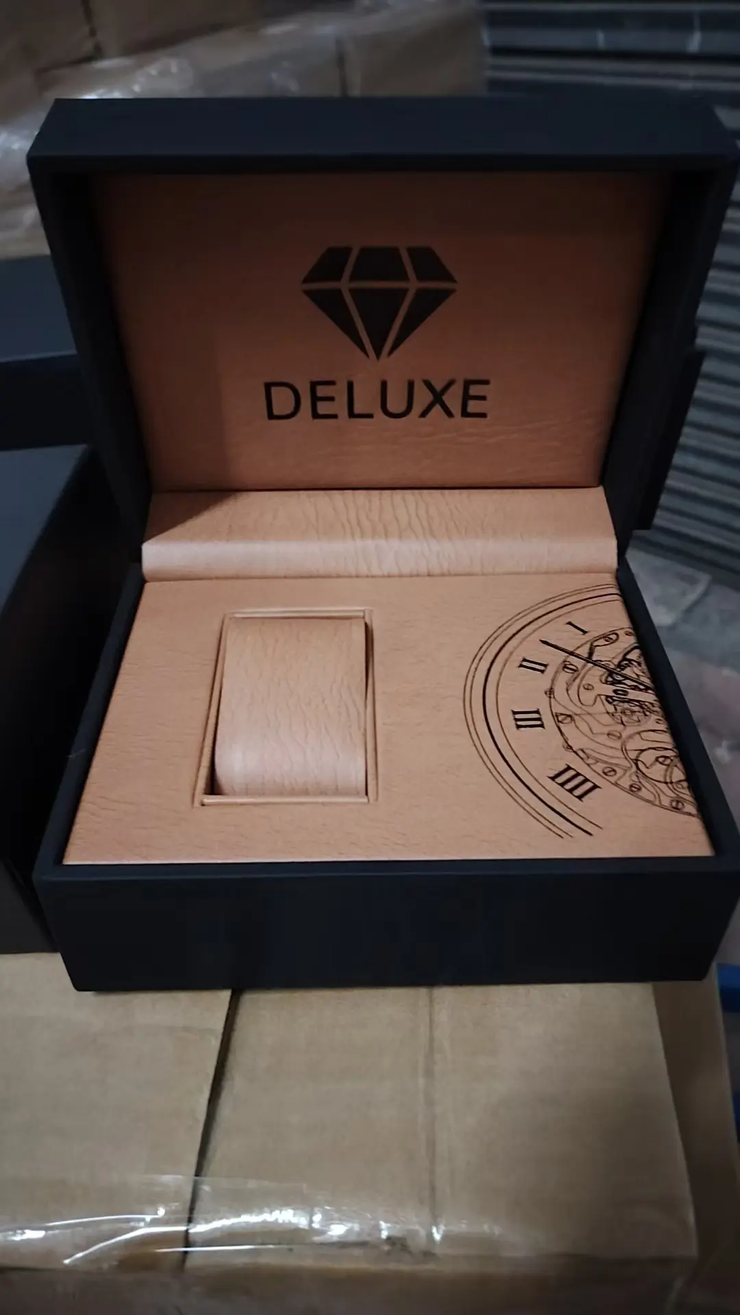 Open PU leather watch box interior — camel suede lining with debossed vintage pocket-watch artwork and custom brand logo on lid