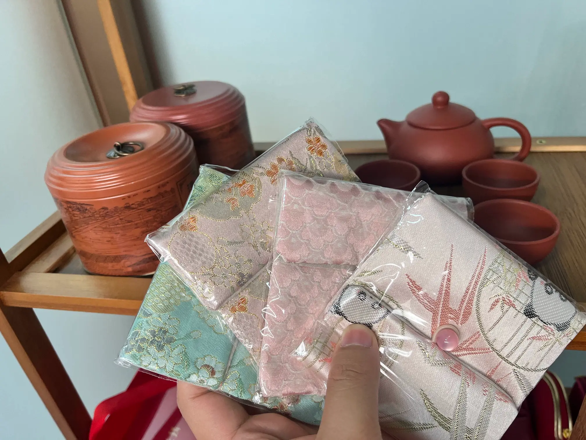 Silk brocade pouches handled with traditional Chinese tea-set background