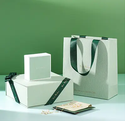 Green and white jewelry packaging with ribbon and cards