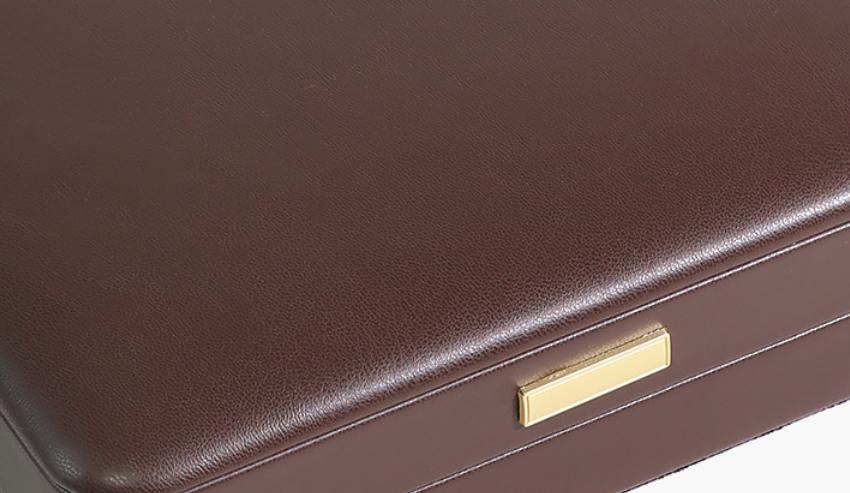 velvet vs leatherette jewelry boxes — brown leatherette box corner with a crisp gold metal logo plate