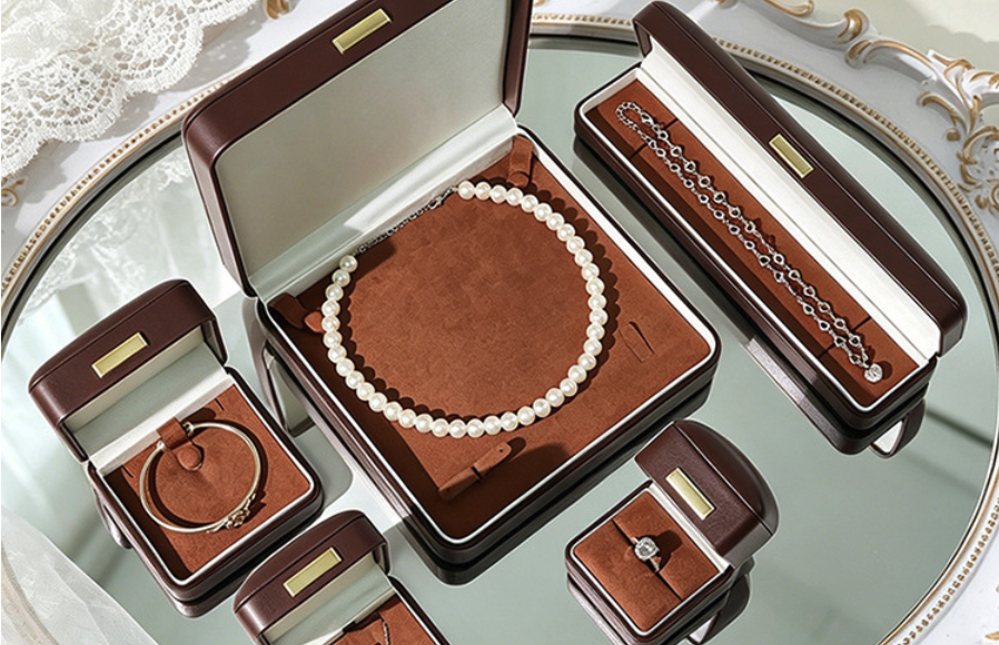 velvet vs leatherette jewelry boxes — a coordinated brown leatherette box set holding pearl and gold jewelry